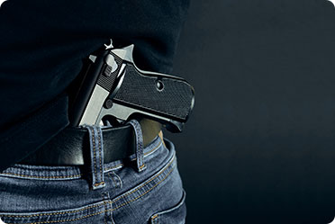 A man concealing a gun in his back pocket.
