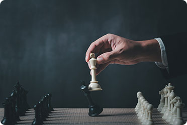 A person in a suit holding a chess piece, strategizing for a game of intellect and skill.