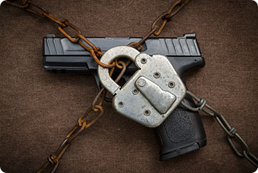 A gun chained with a padlock, symbolizing gun control.