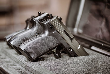 Two handguns neatly arranged side by side inside a protective case.