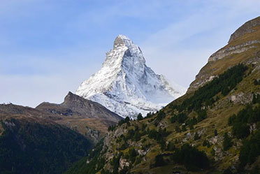 Side view of the mountain, towering against a clear blue sky.