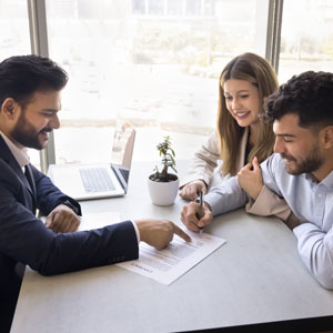Young Couple signing a document related to Trust Administration in front of an attorney - Alex Kincaid Law